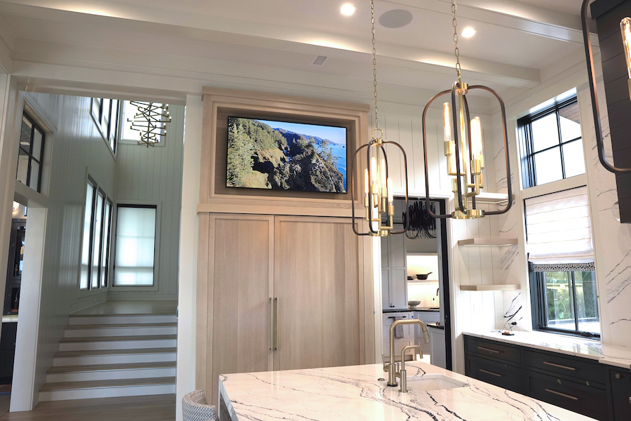 A modern kitchen with lighting, audio, and video solutions.