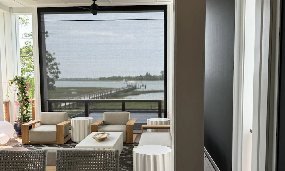 A hot tub in a window overlooking a yard, complemented by outdoor motorized shades.